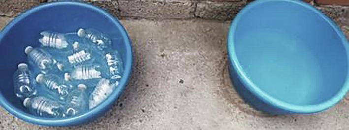 The control container (on the right, no evaporation reduction method) and the container with the evaporation reducer currently under study (on the left, with PET bottles to cover the water surface).